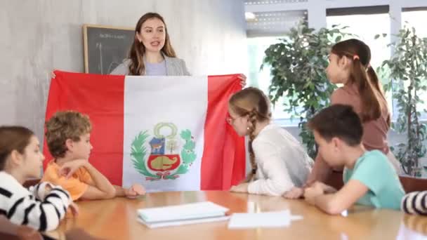 Ενθουσιασμένη Νεαρή Δασκάλα Που Δείχνει Σημαία Του Περού Μαθητές Προσχολικής — Αρχείο Βίντεο