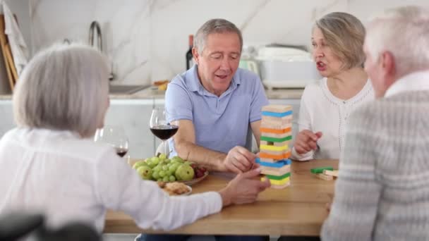 Starší Šťastní Lidé Hrají Doma Žena Odstraňuje Dřevěný Blok Věže — Stock video
