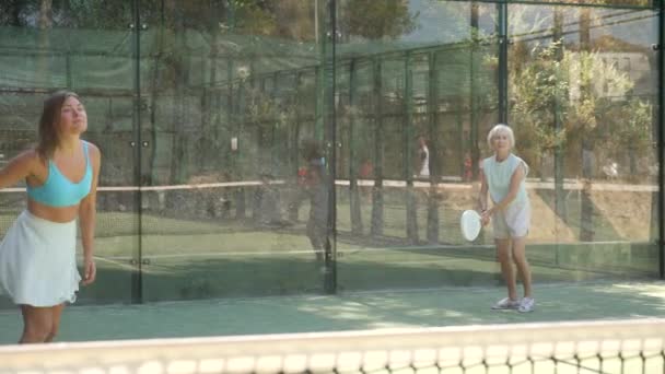 アクティブ女性とともに熱意を持ってプレーパデル上のテニスコート — ストック動画