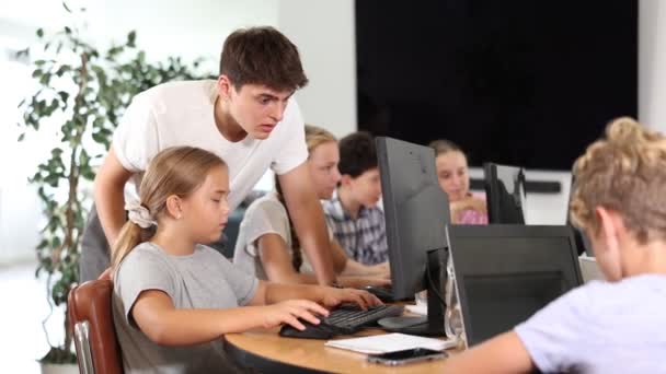 コンピュータに座っている心配な19歳の少女は トレーナーがItコースで彼に何かを説明しながら — ストック動画