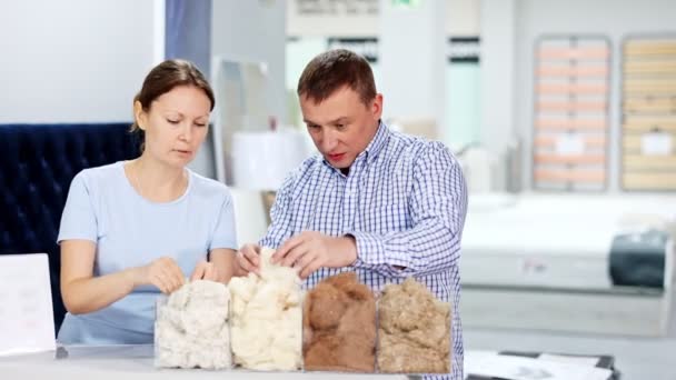 Cuplul Examinează Eșantioane Umpluturi Pentru Saltele Din Magazinul Mobilier Înregistrare — Videoclip de stoc