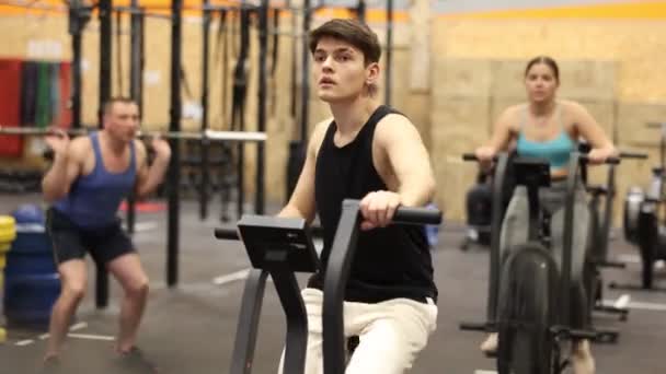 Joven Deportista Enfocado Haciendo Ejercicio Bicicleta Estacionaria Gimnasio Actividad Física — Vídeos de Stock