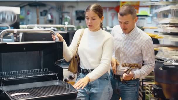Couple Young Man Young Woman Shoppers Choosing Bbq Grill Hardware — Stock Video