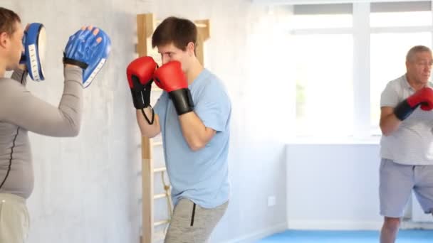 Спортивний Молодий Хлопець Боксерських Рукавичках Практикує Техніку Самозахисту Тренажерному Залі — стокове відео