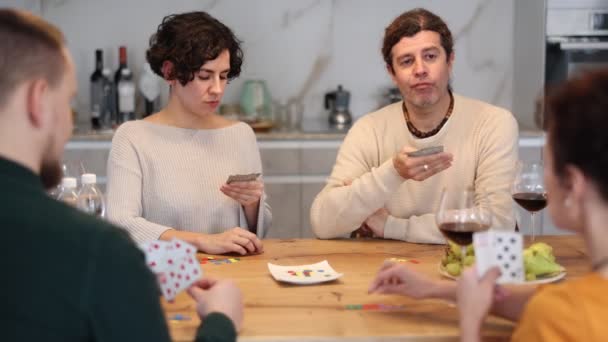 友人のグループは カードゲームポーカーをしています 二人の結婚したカップルは 会議や集会 熱狂的かつ興奮的にゲームの条件を満たすために楽しんでいます — ストック動画