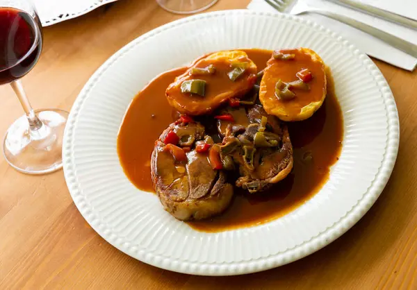 Oven baked lamb with potato and sauce served on white plate