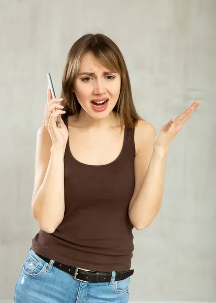 Indignant Young Woman Casual Clothes Talking Mobile Phone Studio Stock Photo