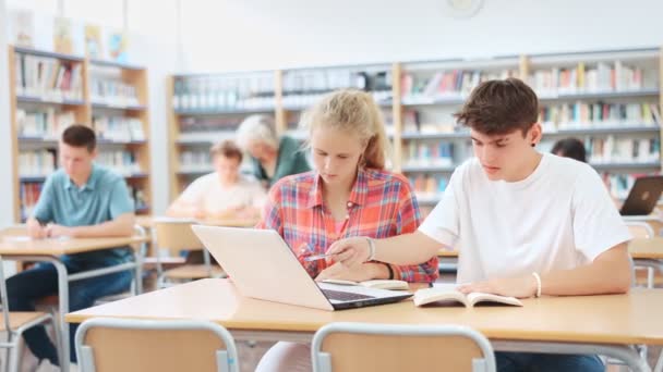 学校図書館で宿題をする2人の子供の肖像画 ラップトップの前に机に座る — ストック動画