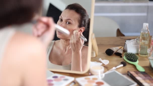 Γαλήνια Ενήλικη Γυναίκα Επιδέξια Εφαρμογή Μακιγιάζ Προσώπου Χρησιμοποιώντας Βούρτσα Ρουζ — Αρχείο Βίντεο