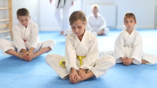 Małe Dzieci Białym Kimono Siedzi Pozycji Motyla Ćwiczenia Rozciągające Się — Wideo stockowe