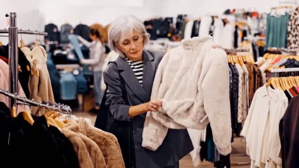 Ηλικιωμένη Γυναίκα Αγοραστής Επιλέγει Γούνα Στο Κατάστημα Ρούχων — Αρχείο Βίντεο