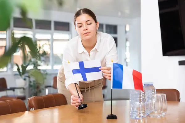 Delegationens Medarbetare Förbereder Förhandlingsbordet För Finlands Och Frankrikes Flagg Stockfoto