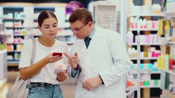 Przyjazny Aptekarz Pomaga Młodej Dziewczynie Elektroniczną Receptą Telefonie Wybierając Lekarstwa — Wideo stockowe