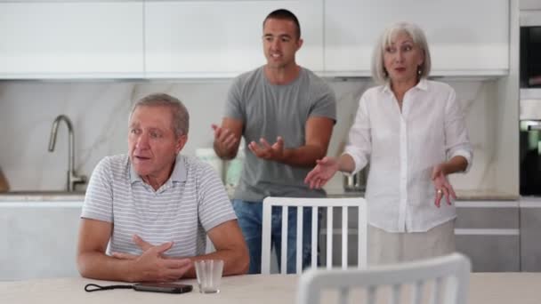 大人の男性はテーブルに座り 妻と息子との対立を解決する方法を考えます 高品質の4K映像 — ストック動画