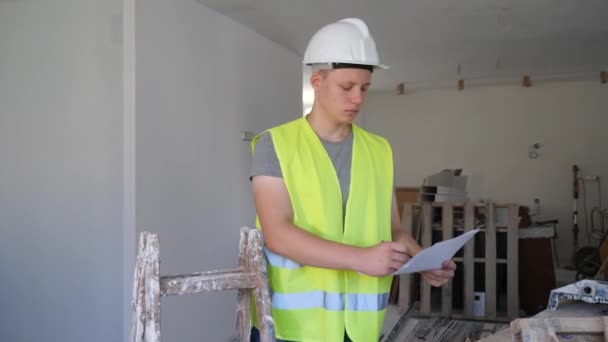 Nastolatek Kamizelce Kasku Sprawdzający Plac Budowy Mieszkaniu Weryfikujący Dokumenty Podczas — Wideo stockowe