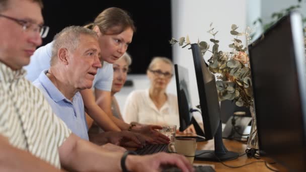 Zaniepokojony Staruszek Siedzący Przy Komputerze Podczas Gdy Trener Wyjaśnia Coś — Wideo stockowe