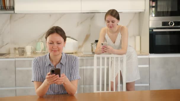 Mother Teen Daughter Sitting Kitchen Table Watching Something Interesting Phones — 图库视频影像