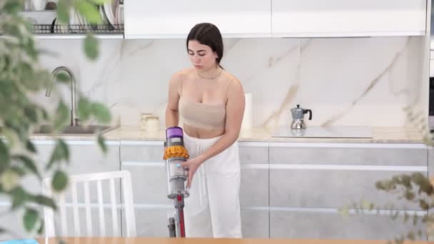 Positive Young Woman Cleaning Floor Using Vacuum Cleaner Kitchen White — Αρχείο Βίντεο