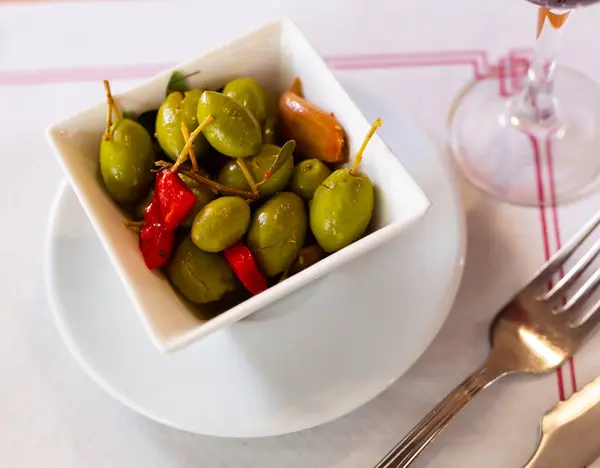 大青橄榄与胡椒和大蒜一起放在碗里 免版税图库图片