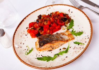 Appetizing roasted salmon steak with a vegetable stew clipart