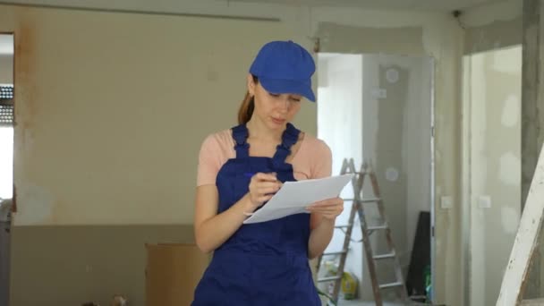 Young Woman Builder Checking Project Documentation While Working Apartment Girl — Stock Video