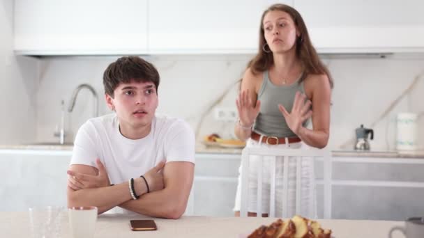 Triste Joven Sentado Mesa Mientras Novia Pelea Con Pie Cocina — Vídeos de Stock