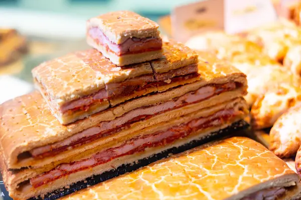 stock image Hornazo pie stuffed with loin, bacon and chorizo, typical product of spanish Salamanca, displayed for sale at local market