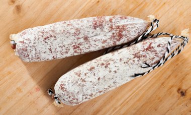 Close-up of spiced spanish longaniza sausages at wooden background clipart