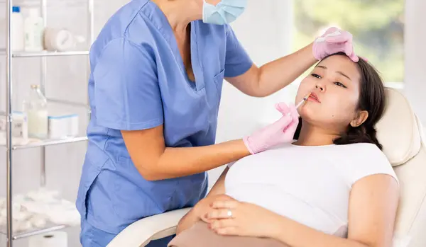 stock image Woman getting facial beauty treatment by professional medicine worker in medical center