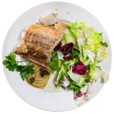 Served on white plate, piece of roasted alfonsino fish pairing delightfully with caramelized onion and fresh green salad, perfect for refined dinner. Isolated over white background clipart