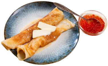 Pancakes with piece of butter and red caviar dished up in flat service plate. Traditional Russian cuisine. Isolated over white background clipart