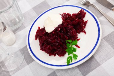 Delicious vegetable salad of grated boiled beets served with homemade mayonnaise and fresh greens clipart