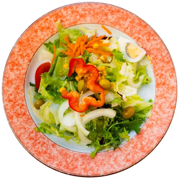 stock image There are large pieces of fresh vegetables on plate. Vitamin salad of fresh vegetables, lettuce, olives, onions and half of egg. Isolated over white background