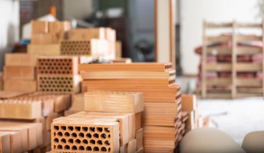 Closeup of stack of red bricks inside building under construction. Building materials prepared for work.. clipart