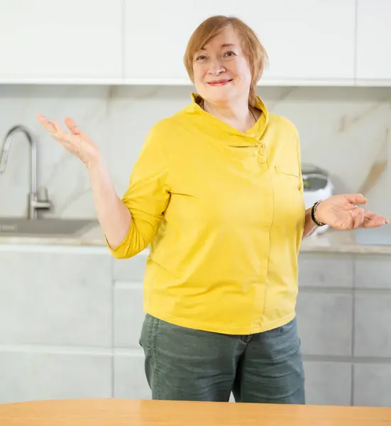 Stock image Portrait of a confident mature woman in a good mood standing in a home kitchen