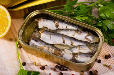 Tin can with smoked sprats, sardines, closeup. High quality photo clipart