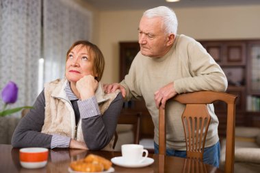 Senior man asking for forgiveness from offended wife clipart