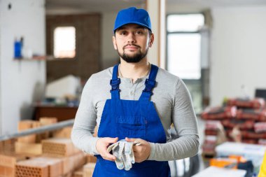 Portrait of a professional confident builder standing on a construction site indoors clipart