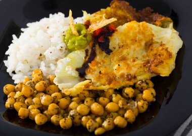 Image of chicken thighs with cabbage leaves in batter, cheakpea and rice at plate clipart