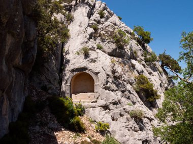 Rock-cut tombs carved into vertical cliffs at Termessos, modern Antalya province, Turkey. clipart