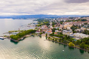 Picturesque view of Lausanne city on shore of Lake Geneva on background of mountains on summer day, Switzerland clipart