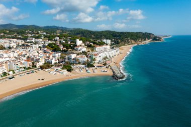 Birds eye view of Sant Pol de Mar, Spain. Residential building along Mediterranean sea coast and beach visible from above. clipart