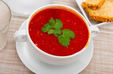 Just prepared portion of red beetroot soup, svekolnik, served on table with parsley. clipart