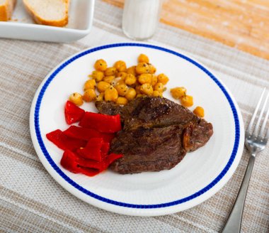 Popular appetizing dish of juicy roasted beef with chickpeas and vegetables clipart