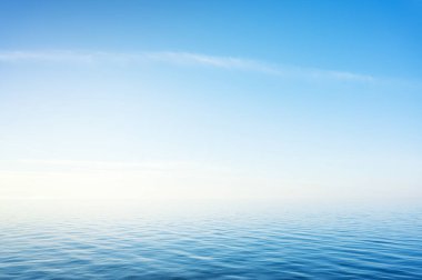 Blue sky over sea or ocean water surface. Nature background scene. clipart