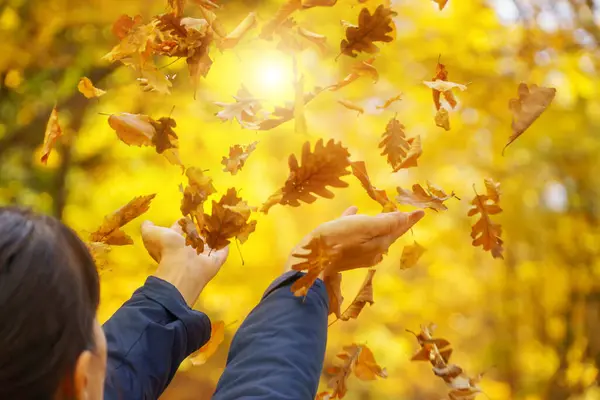 女性の手は秋の葉をキャッチしようとします エモーショナルシーン — ストック写真