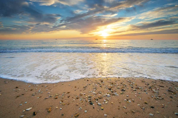 日没の海岸に砂と岩がある 自然景観コンポジション ストック画像