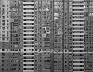 Bir sürü penceresi olan apartman bloğu. Yapılandırılmış ve arka plan yapılandırılmış tasarım. Büyük şehirde hayat.