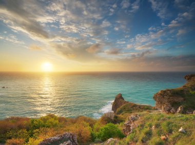 Kayalıklarda gün batımı. Güzel bahar doğası ve deniz manzarası. Kompozisyonu gevşet.