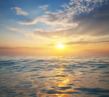 Gün batımında renkli dramatik gökyüzü bulutlarının ve deniz dalgalarının doğa arkaplanı. Tasarım elementi.